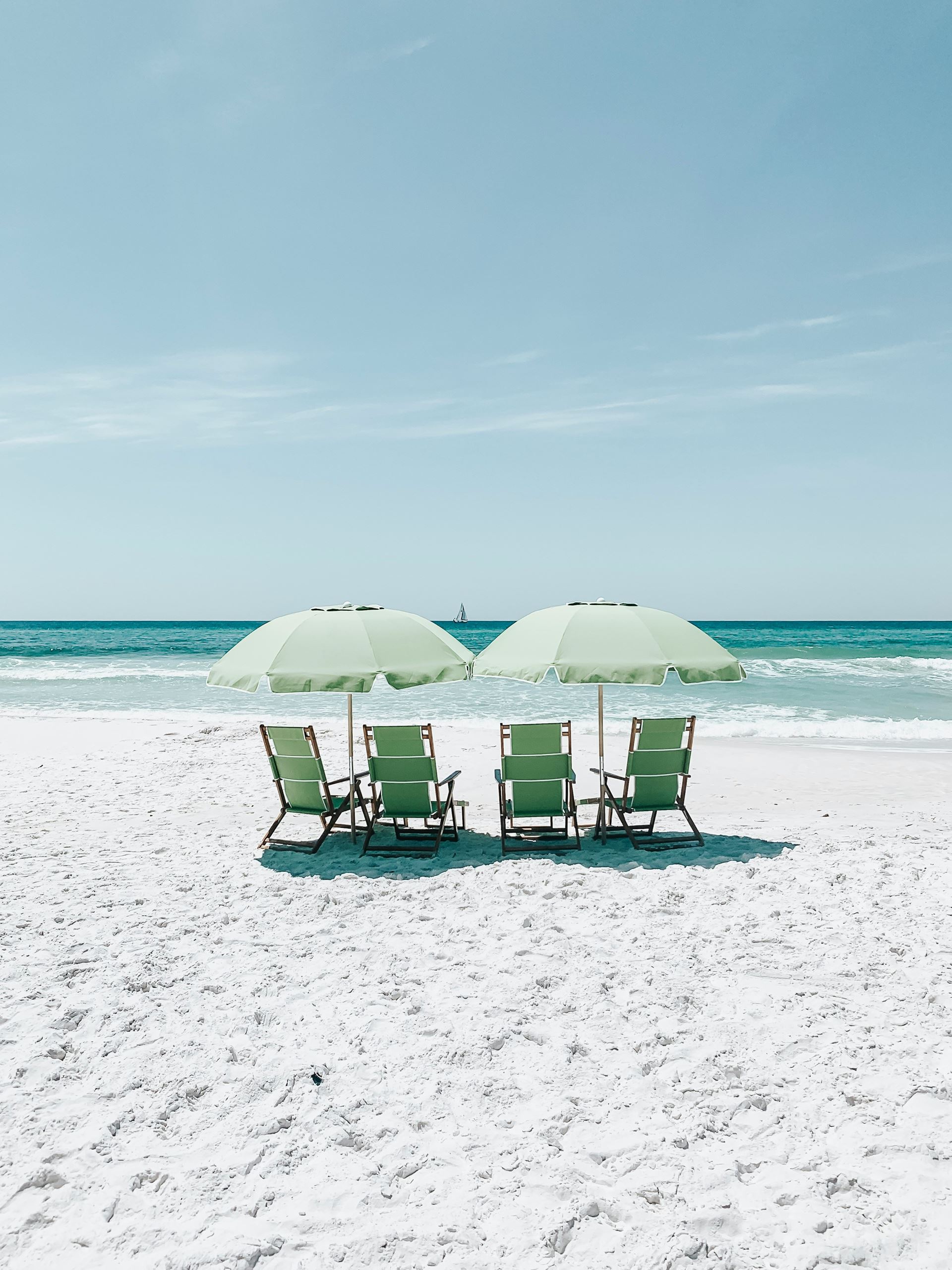 deck chairs on a beach with sun umbrellas shading them